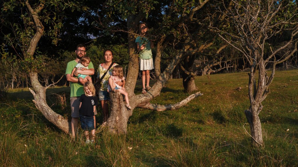 Familiefoto aan boom met dochter in de schaduw